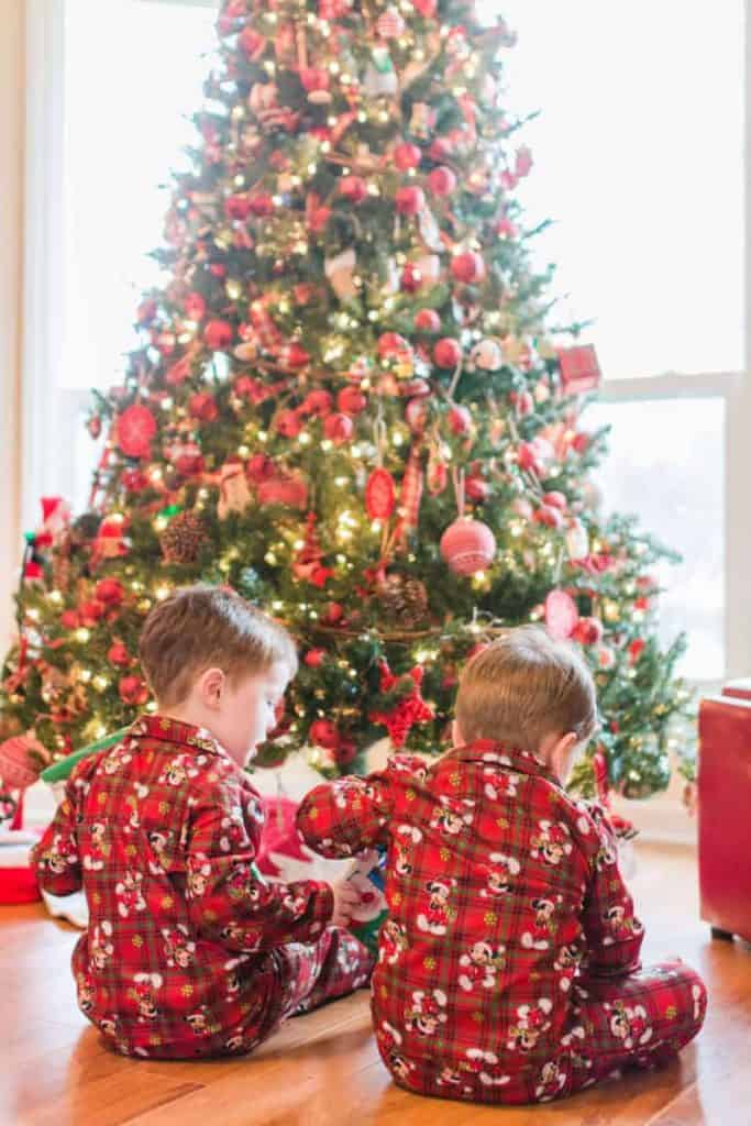 2 little boys in front of the Christmas Tree with plaid christmas pajamas