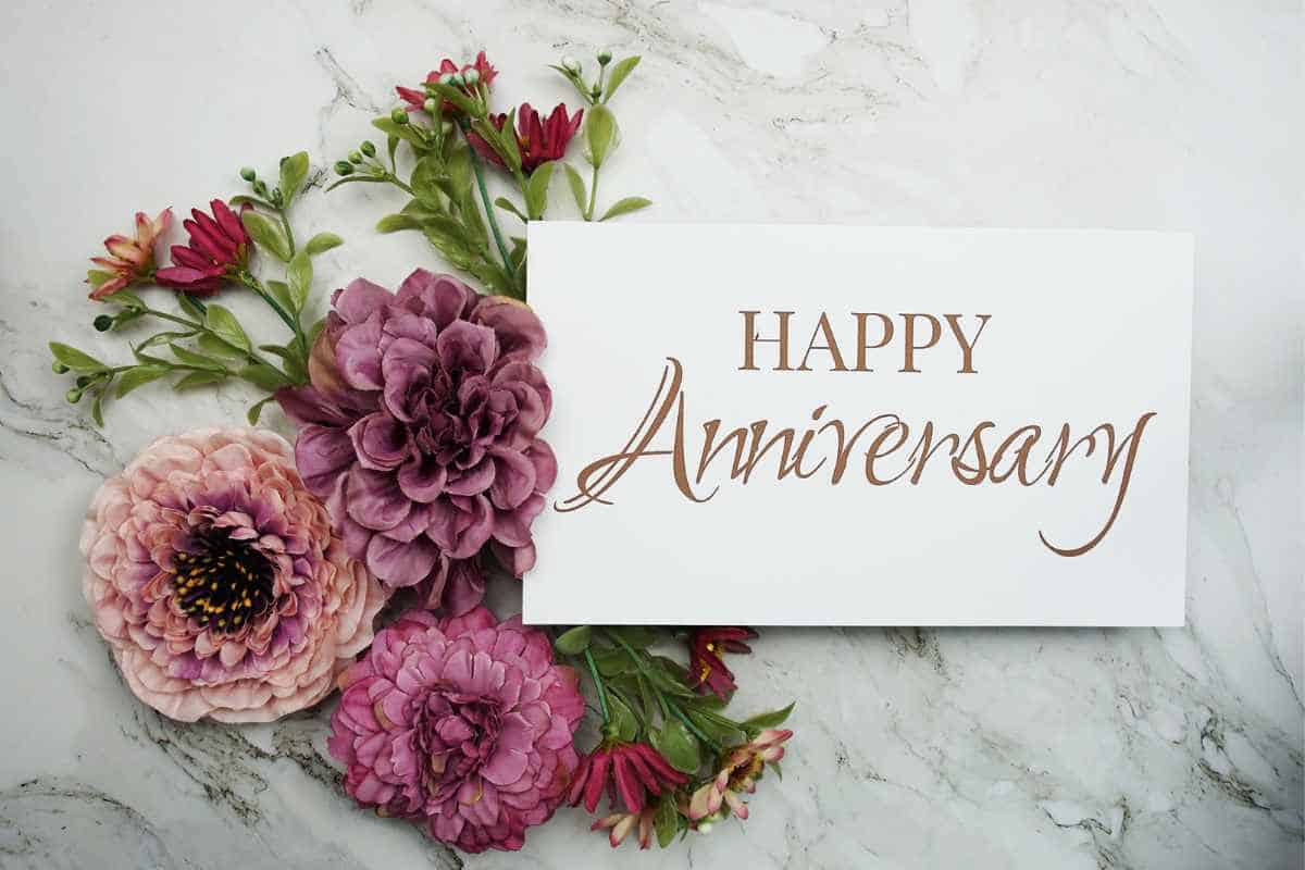 Happy Anniversary sign surrounded by pink flowers