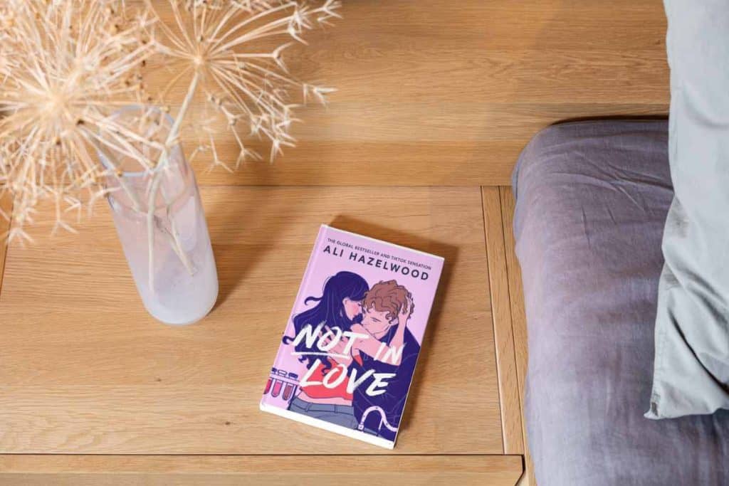 A book on the bedside table titled "Not In Love"