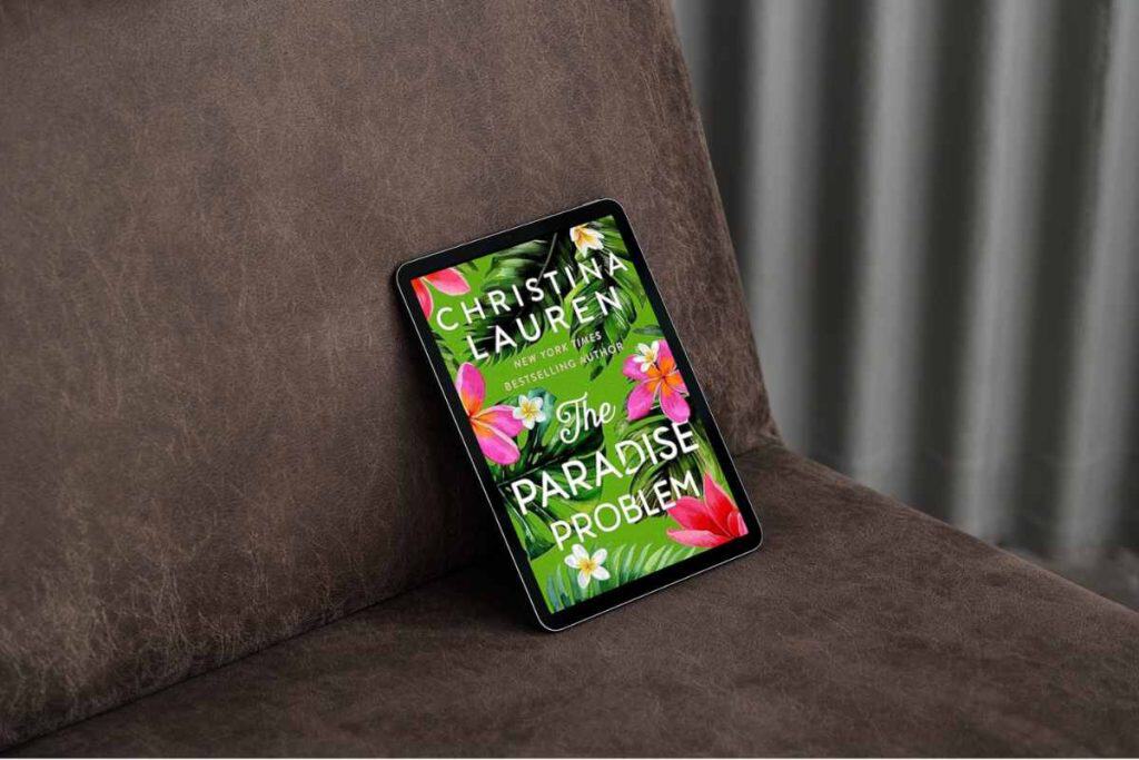 E-reader with a book on it titled "THe Paradise Problem" propped up in a chair
