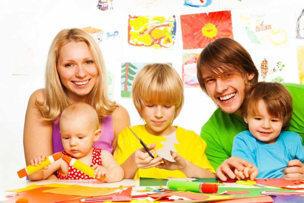 A family enjoying craft time with paper, scissors and glue