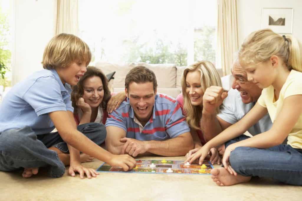 A family in the living room floor playing a board game