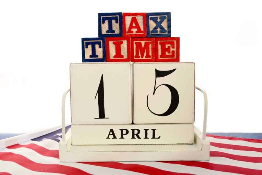 A block calendar set to April 15, with wooden block letters that spell out Tax Time