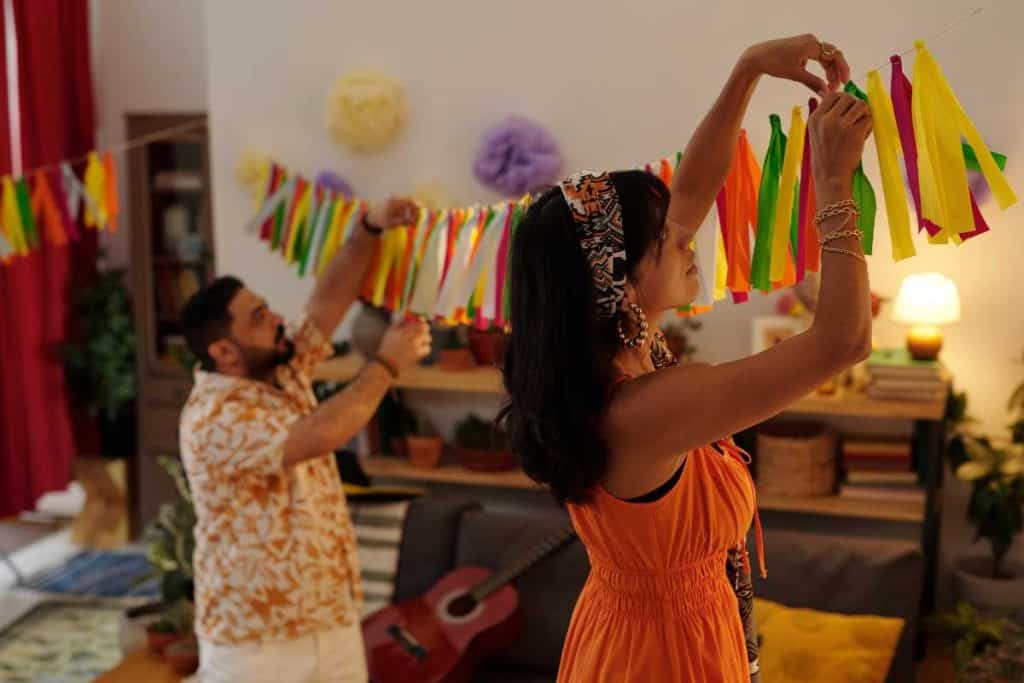 Family decorating for Cinco De Mayo by hanging up colorful banners in their home
