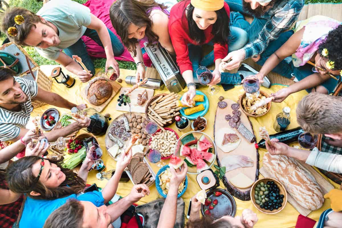 Large family gathering around a table for an outdoor picnic