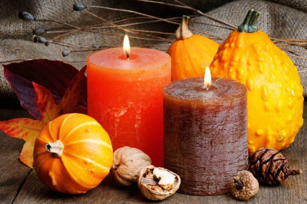 Gourds and pumpkins and candles all together in an arrangement