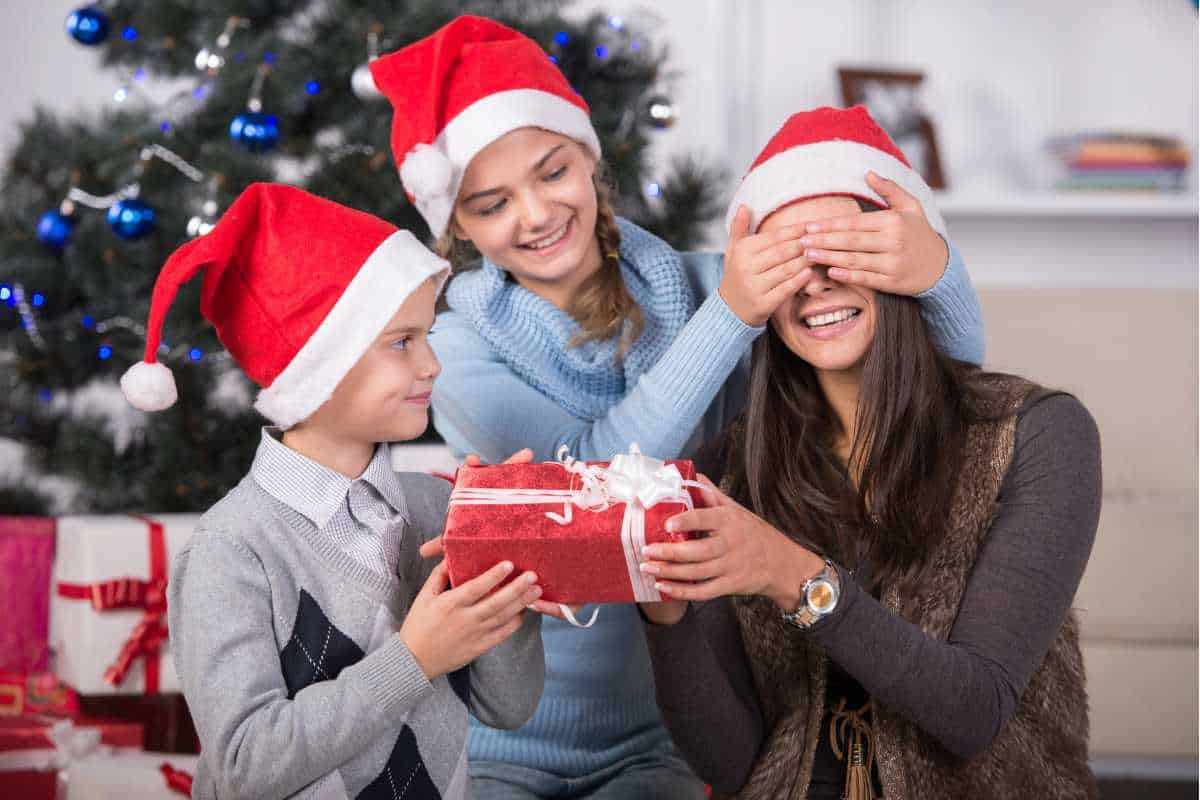 Mom being surprised with Christmas presents from her kids