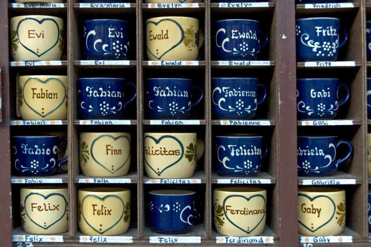 Rack of coffee mugs with personalized names on them.