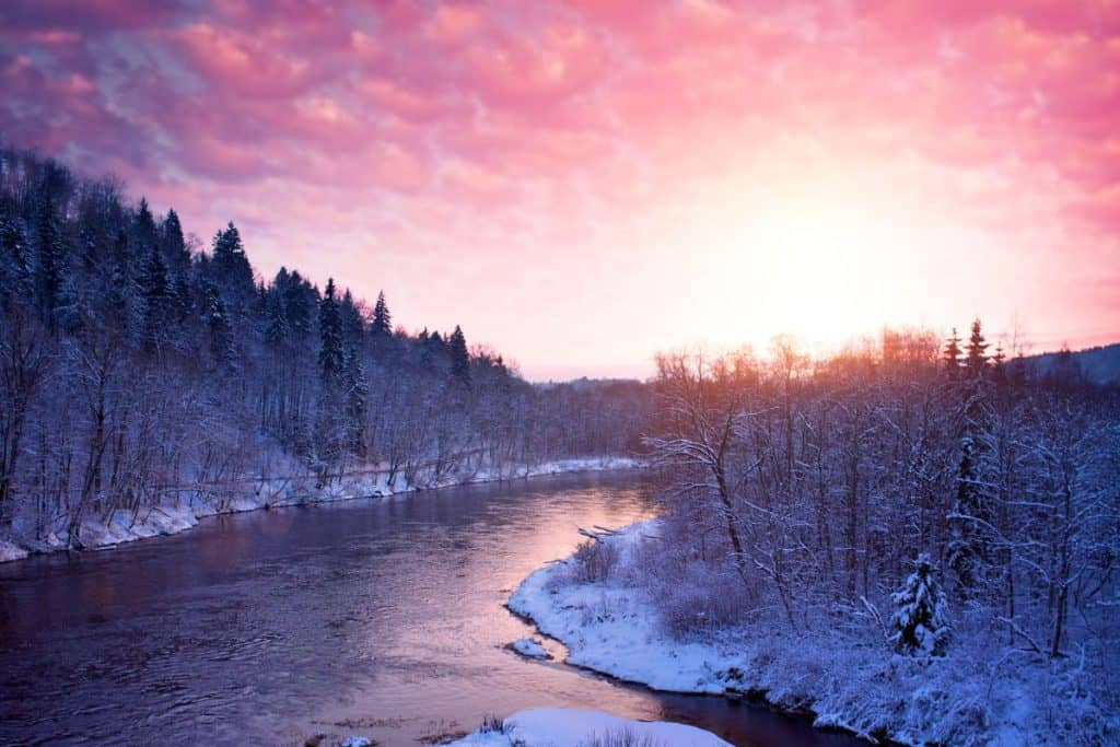 Gorgeous sunset with a river with snow on the banks