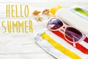 A striped beach twel with sunscreen and sunglasses and a caption that says "Hello Summer"